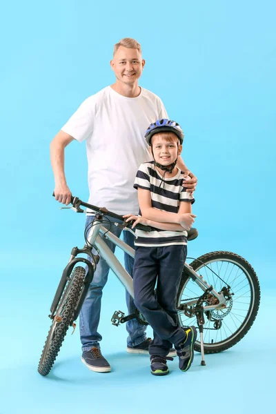 色の背景に自転車を持つ父と彼の息子 — ストック写真
