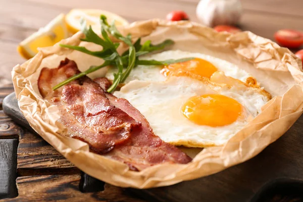 Tasty fried eggs and bacon on wooden table, closeup — Stock Photo, Image