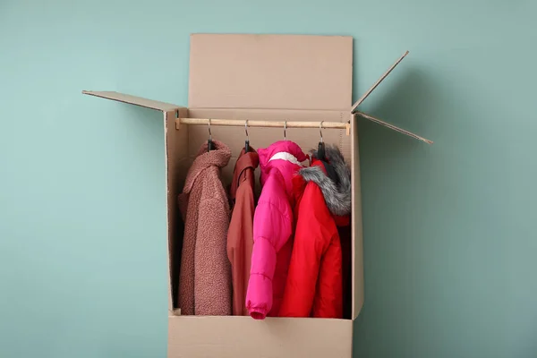 Wardrobe box with clothes on color background — Stock Photo, Image