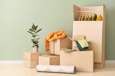 Giysi ve diğer şeyler ev renk duvara yakın hareket için paketlenmiş kutular