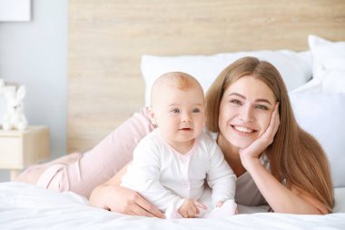 Mutlu anne ve evde küçük şirin bir bebek.