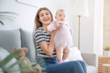 Mutlu anne ve evde küçük şirin bir bebek.