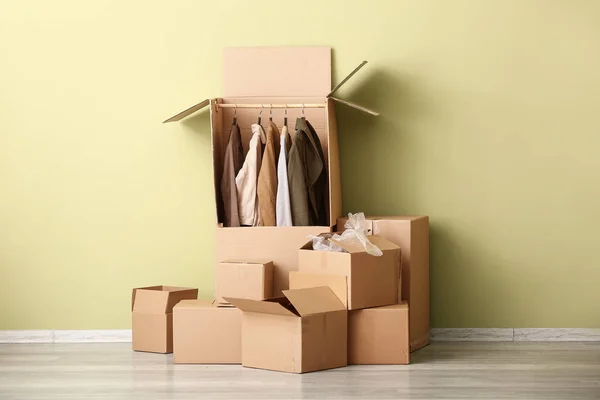 Wardrobe boxes with clothes near color wall — Stock Photo, Image