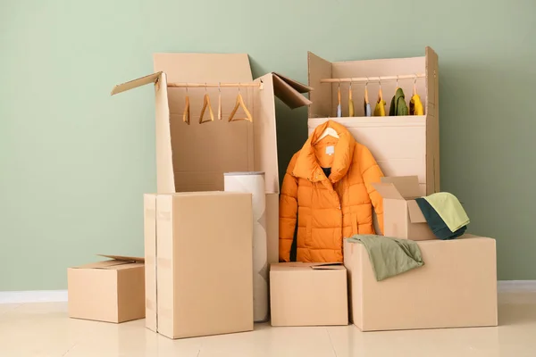 Wardrobe boxes with clothes near color wall