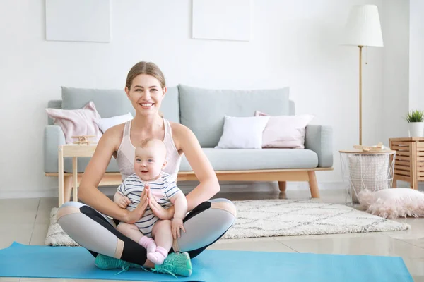 Mãe de treinamento com bebê pequeno bonito em casa — Fotografia de Stock