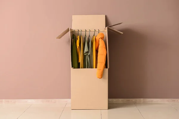 Wardrobe box with clothes near color wall — Stock Photo, Image