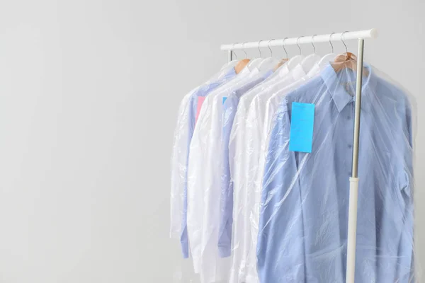 Rek met kleding na chemisch reinigen op lichte ondergrond — Stockfoto