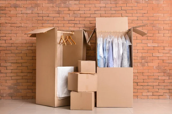 Cajas de armario con ropa cerca de pared de ladrillo —  Fotos de Stock