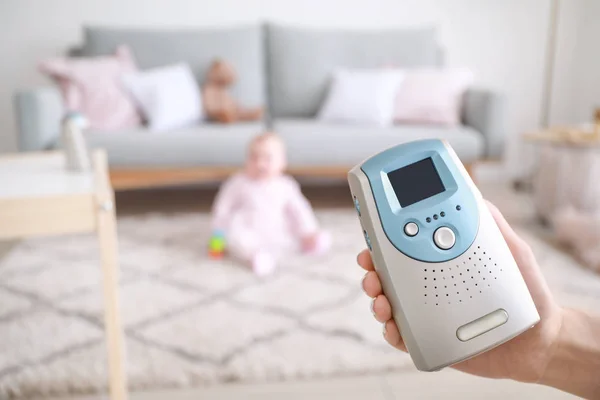 Mano femenina con monitor de bebé moderno y niño pequeño en el fondo — Foto de Stock