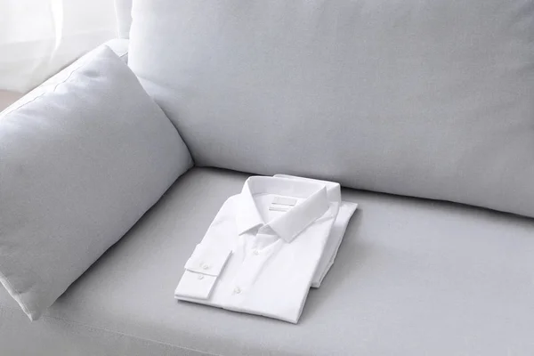 Folded shirts after dry-cleaning on sofa