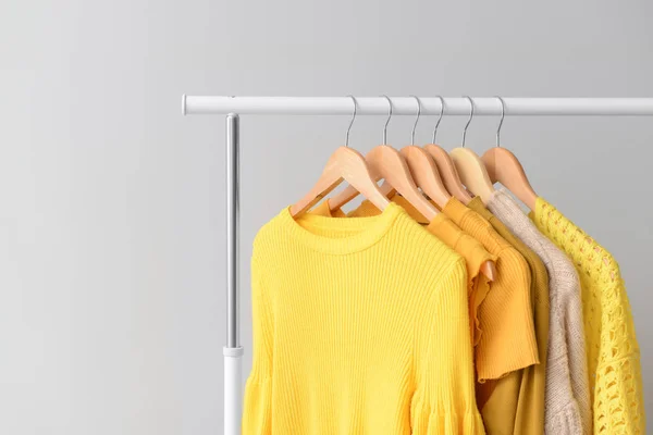 Rack with clothes after dry-cleaning on light background — Stock Photo, Image