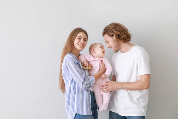 Gelukkige ouders met schattige kleine baby op lichte achtergrond — Stockfoto
