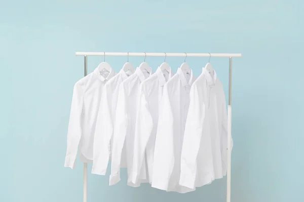 Rack with clothes after dry-cleaning on light background — Stock Photo, Image