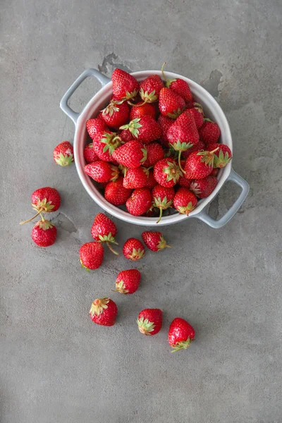 Topf mit reifen roten Erdbeeren auf grauem Hintergrund — Stockfoto
