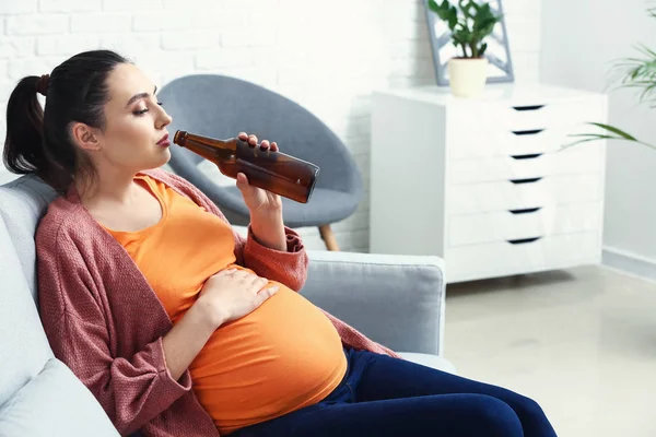 Mulher grávida bebendo cerveja em casa — Fotografia de Stock