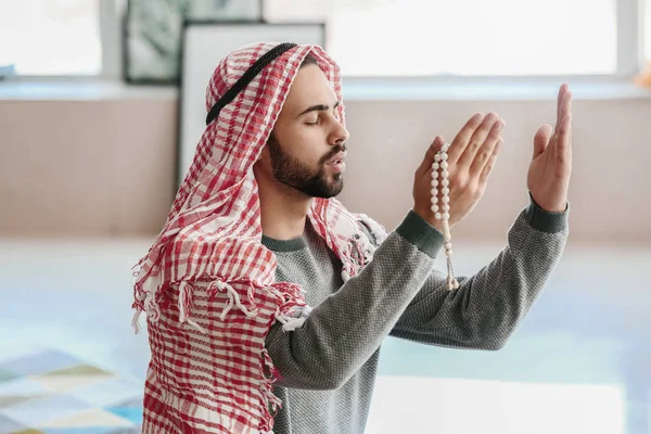 Young Muslim man praying indoors — Stock Photo, Image