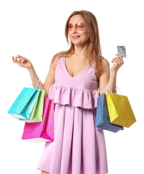 Mulher madura com sacos de compras e cartão de crédito no fundo branco — Fotografia de Stock