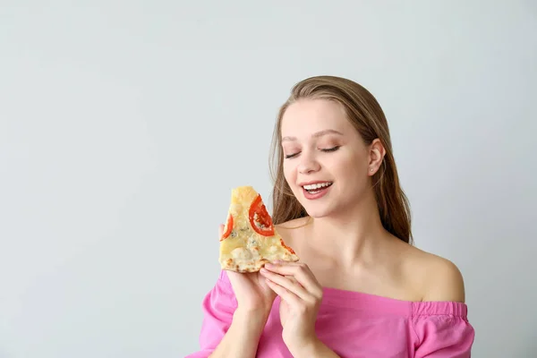 Mulher bonita com pizza saborosa no fundo claro — Fotografia de Stock