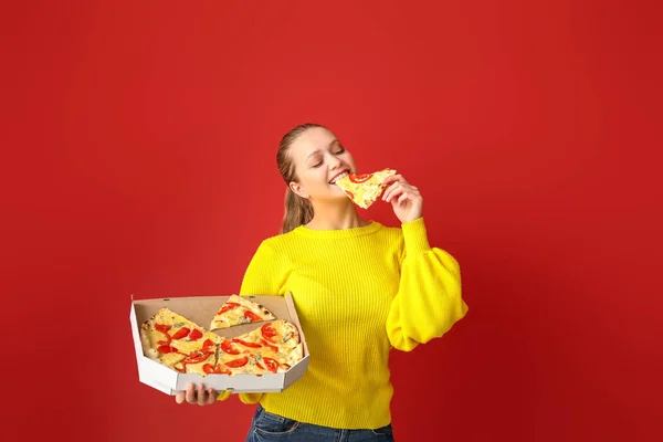 Piękna kobieta jedząca smaczną pizzę na tle koloru — Zdjęcie stockowe