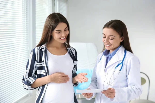 Female gynecologist working with pregnant woman in clinic — Stock Photo, Image