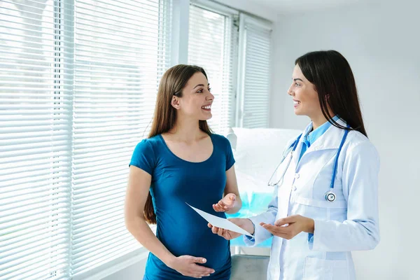 Female gynecologist working with pregnant woman in clinic — Stock Photo, Image