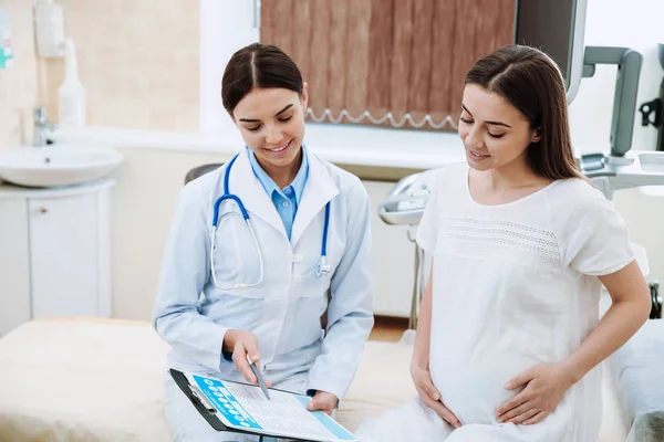 Frauenärztin arbeitet mit schwangerer Frau in Klinik — Stockfoto