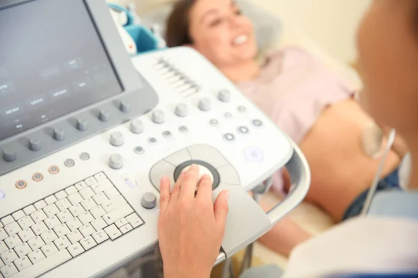 Female doctor conducting ultrasound examination of woman in clinic — Stock Photo, Image