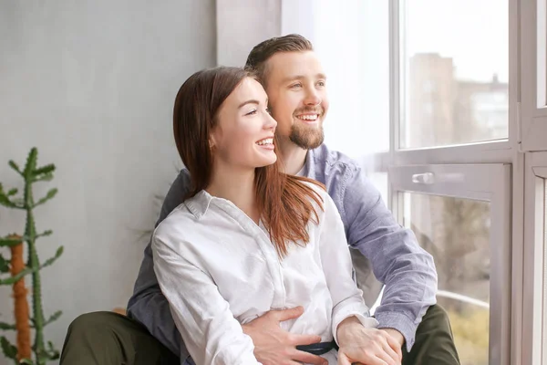 Casal feliz descansando perto da janela em casa — Fotografia de Stock