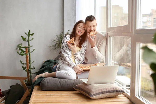 Happy couple watching movie near window at home — Stock Photo, Image