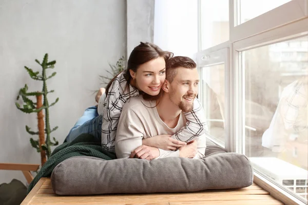 Happy couple resting near window at home — Stock Photo, Image