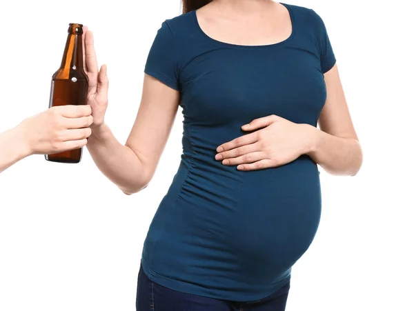 Mulher grávida rejeitando garrafa de cerveja no fundo branco — Fotografia de Stock