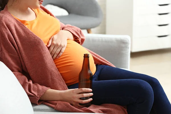 Pregnant woman drinking beer at home — Stock Photo, Image