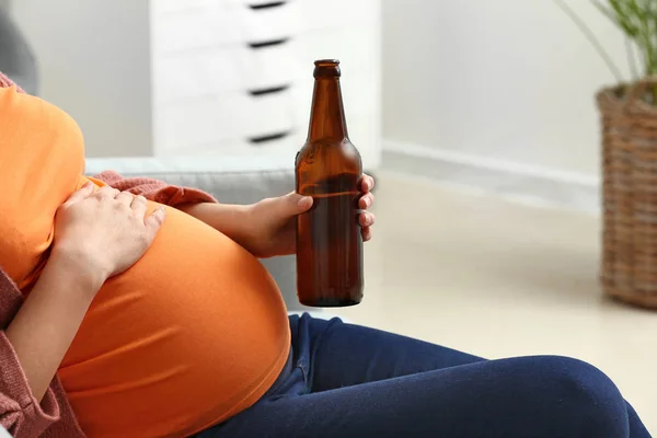Mulher grávida bebendo cerveja em casa — Fotografia de Stock