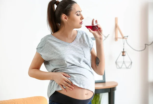 Mulher grávida bebendo álcool em casa — Fotografia de Stock