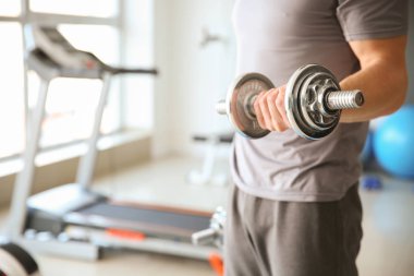 Spor salonunda Dambıl ile sportif genç adam eğitim