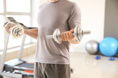 Spor salonunda Dambıl ile sportif genç adam eğitim