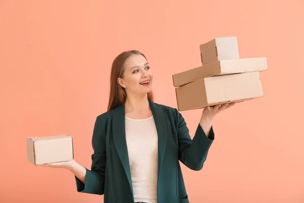 Młoda kobieta z kartonowe pudełka na kolorowym tle — Zdjęcie stockowe