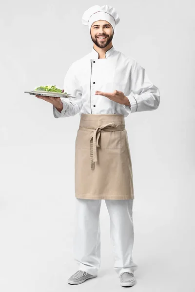 Bonito chef masculino com salada no fundo branco — Fotografia de Stock