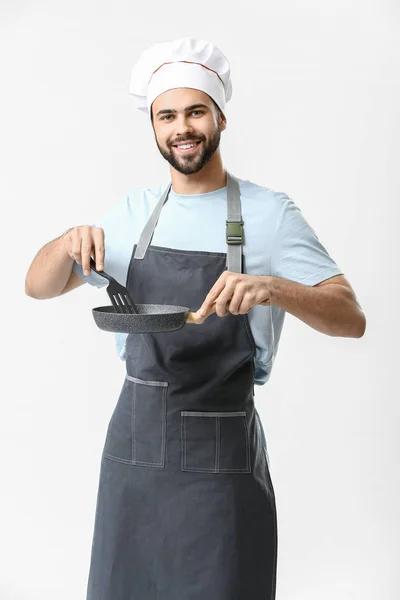 Bonito chef masculino com frigideira no fundo branco — Fotografia de Stock
