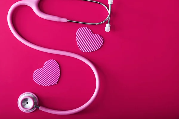 Stethoskop mit Herzen auf farbigem Hintergrund — Stockfoto