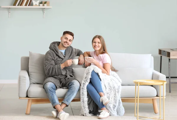 Feliz pareja joven descansando juntos en el sofá en casa —  Fotos de Stock