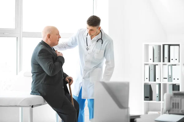 Médico examinando hombre mayor en asilo de ancianos —  Fotos de Stock