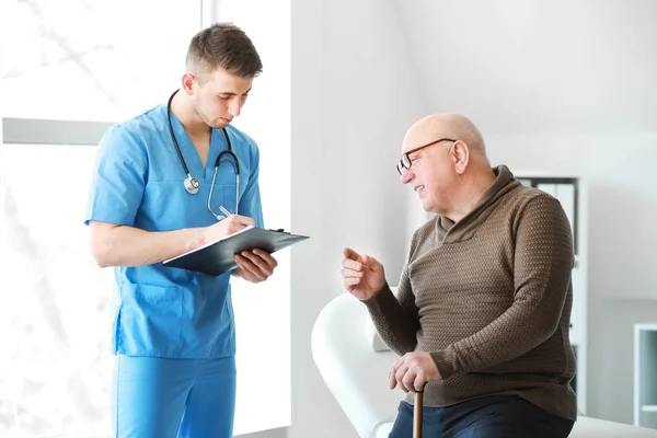 Arts onderzoekt Senior man in verpleeghuis — Stockfoto