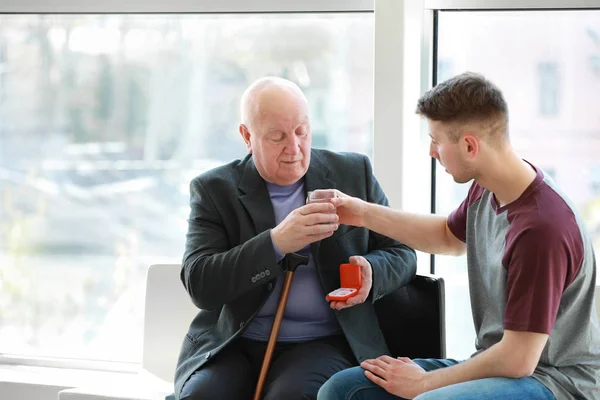 Manlig vårdgivare som ger piller till Senior man i sjuk hem — Stockfoto