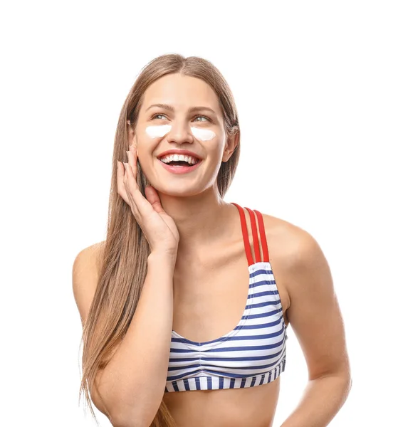 Beautiful young woman applying sun protection cream against white background — Stock Photo, Image