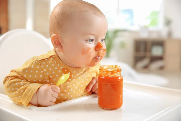 Cute little baby eating tasty food at home — Stock Photo, Image