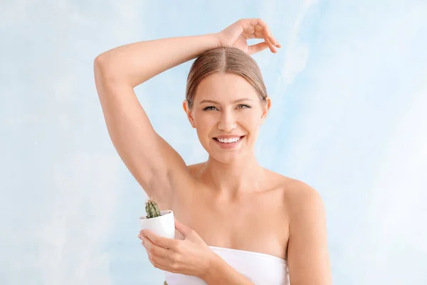 Beautiful young woman with cactus on light background. Depilation concept — Stock Photo, Image