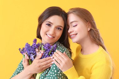 Arka planda sümbül çiçekleri olan güzel genç kadınlar.