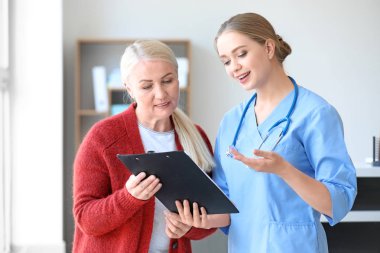 Tıbbi asistan Olgun kadın klinikte tanısı açıklayan