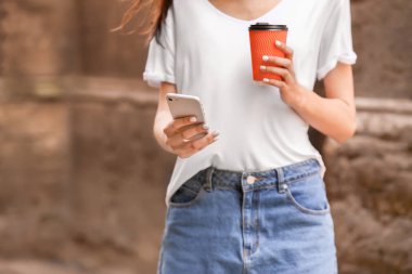 Cep telefonu ve kahve açık havada Genç kadın